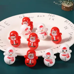 Close-up van kerst tuimelaar speelgoed met Kerstman en sneeuwpop op een wit bord