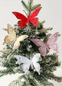 Detailansicht von farbenfrohen Glitzer-Netz-Schmetterlingen am verschneiten Weihnachtsbaum