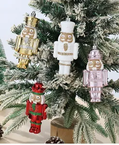 Détail de quatre décorations de casse-noisettes suspendues à un sapin de Noël vert