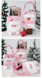 Primer plano de bolsas de regalo de Navidad rosas con Papá Noel y muñeco de nieve