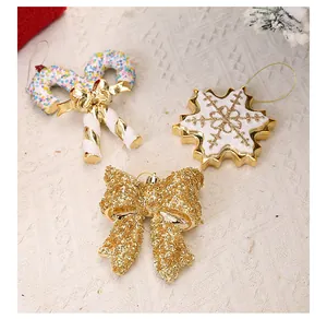 Detailweergave van gouden kerstversieringen met sneeuwvlok, zuurstok en strik.
