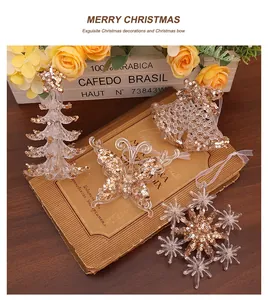 Detail view of clear acrylic Christmas ornaments with gold sequins on a vintage book background