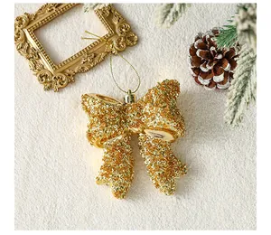 Gedetailleerde opname van een gouden glitter kerststrik ornament op een witte achtergrond
