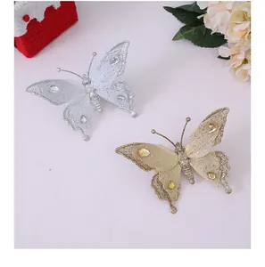 Detail von glitzernden Netz-Schmetterlings-Ornamenten in Silber und Gold für den Baum