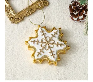 Detail van een goudomrand kerstsneeuwvlok ornament met een witte glitter afwerking