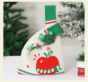 Primer plano de una bolsa de punto navideña con diseño de manzana y árbol festivo
