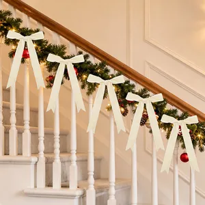 Set of creamy white velvet Christmas bows decorating a festive staircase garland