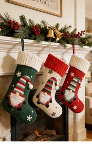Primer plano de tres calcetines de Navidad de felpa con motivos de gnomos en chimenea