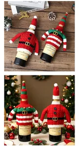Détail de housses de bouteille de vin de Noël tricotées avec des motifs de Père Noël.