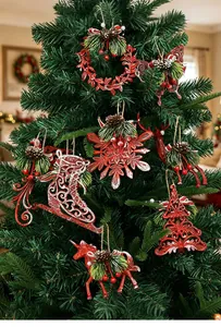 Assorted red Christmas tree ornaments including snowflakes and reindeer on a pine tree.