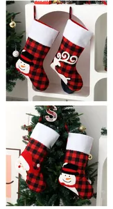 Detalle de calcetines navideños de cuadros rojos y negros con bordados de Papá Noel y nieve.