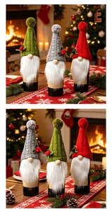 Couvre-bouteilles de vin gnome de Noël tricotés en rouge, vert et gris sur la table