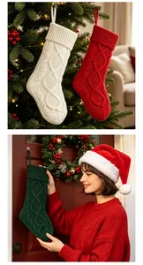 Chaussettes de Noël géantes en tricot torsadé accrochées à un sapin par un mannequin.