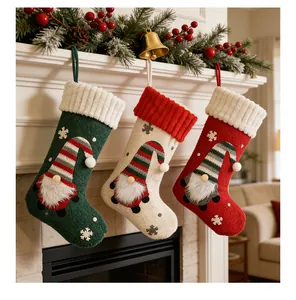 Tres calcetines de Navidad decorativos de felpa con gnomos colgados en una chimenea