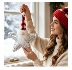 Funkelnder Pailletten-Stern Weihnachtsgnom Anhänger, handgehalten vor Schneefenster