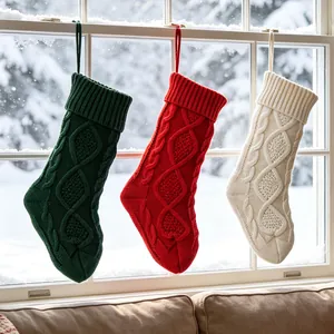Lot de trois grandes chaussettes de Noël en maille torsadée suspendues à la fenêtre