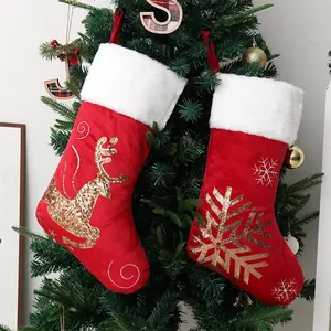 Red velvet Christmas stockings with gold sequin reindeer and snowflake patterns on tree