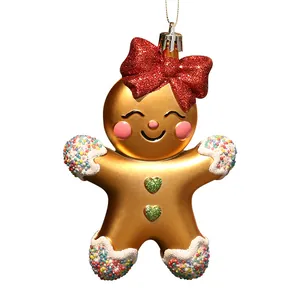Cute golden gingerbread girl Christmas tree hanging ornament with a red glitter bow