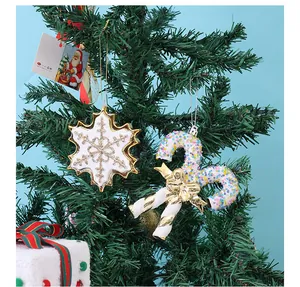 Detailweergave van kerst-sneeuwvlokken en glinsterende zuurstokken hangend aan een boom.