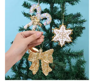 Detailopname van gouden glitterstrik en sneeuwvlokversieringen op een kerstboom.