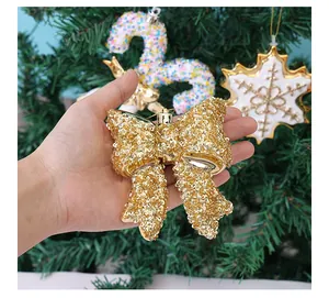 Gedetailleerd overzicht van een sprankelende gouden kerstboomstrik met lovertjes.