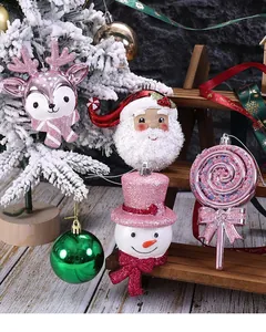 Close-up of pink glitter Christmas tree ornaments like Santa and snowman