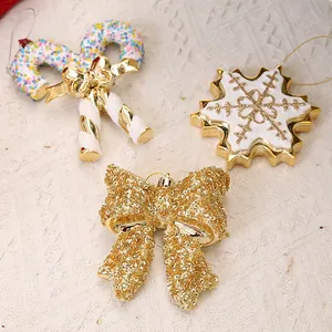 Gouden glitter kerstboomhangers in de vorm van een sneeuwvlok en feestelijke strikken