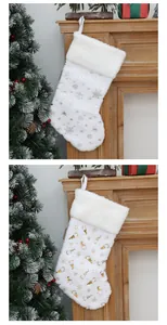 Dettaglio calze di Natale in peluche bianco con stampe di fiocchi oro e argento.