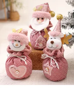 Detailansicht von drei rosa glitzernden Weihnachtsgeschenktüten mit Festfiguren