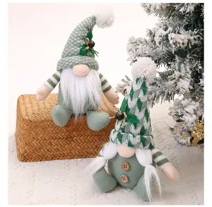 Detailansicht von salbeigrünen Weihnachtswichteln mit Strickmützen und weißen Fellbärten.