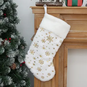 Calza di Natale in finta pelliccia bianca con fiocchi d'oro appesa al caminetto