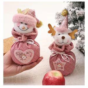 Detailansicht von rosa Plüsch-Weihnachts-Apfelbeuteln mit Schneemann- und Rentierfiguren.