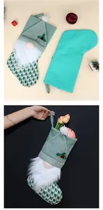 Primo piano della calza di Natale in maglia verde con design a gnomo e barba bianca.
