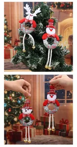 Plush Christmas ornaments with long legs and bells shown on a tree and held by hand