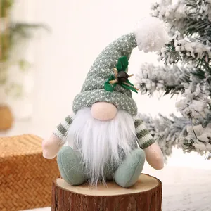 Handgefertigter Weihnachtswichtel aus Plüsch mit grüner Strickmütze auf Holzsockel