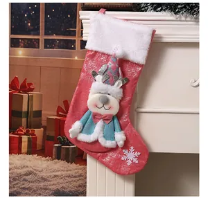 Nahaufnahme eines roten 3D-Rentier-Weihnachtsstrumpfs an einem weißen Kamin in Festdeko