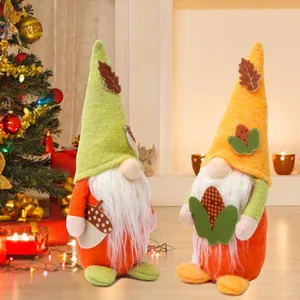 Gnomi di peluche per la festa del raccolto con decorazioni di ghianda e mais.