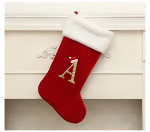 Detail of red Christmas stocking with golden letter A and white fuzzy trim.