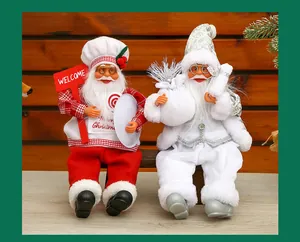 Detailed view of two sitting Santa Claus dolls in red and white festive outfits.