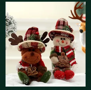 Macro de adorables figuras de peluche de muñeco de nieve y reno navideño sobre nieve artificial