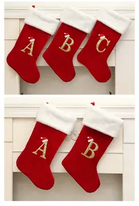 Detailed view of red velvet Christmas stockings with gold glitter letters A, B, and C