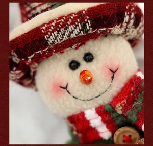 Detalle macro de la cara de un muñeco de nieve de peluche navideño con nariz de zanahoria
