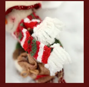 Detalle macro de un muñeco de nieve navideño con bufanda de punto suave en rojo y blanco