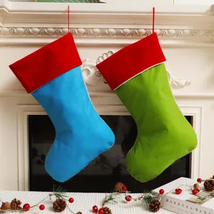 Große festliche blaue und grüne Weihnachtssocken, die an einem Kamin hängen dekor