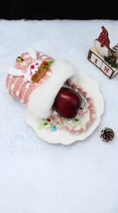 Nahaufnahme einer rosa gestrickten Weihnachtstüte mit Schneemann-Plüschfigur und weißem Pelz