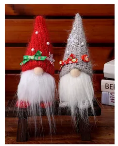 Nahaufnahme von zwei festlichen Weihnachtsgnomen mit Strickmützen auf einer Holzbank