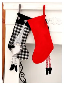 Vue détaillée de chaussettes de Noël festives avec gnome et jambes en peluche sur cheminée.
