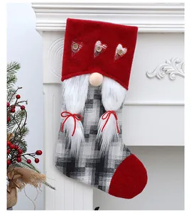 Calcetín de Navidad de gnomo con gorro rojo y estampado de cuadros en la chimenea