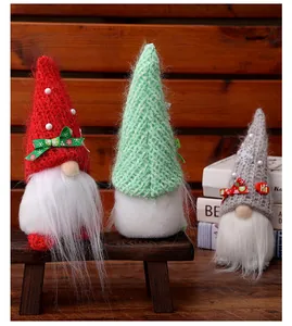 Detailansicht von drei Weihnachtsgnomen mit Strickmützen auf einer Holzbank
