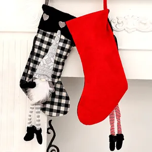 Chaussettes de Noël rouges et à carreaux avec décor de gnome et jambes en peluche suspendues.